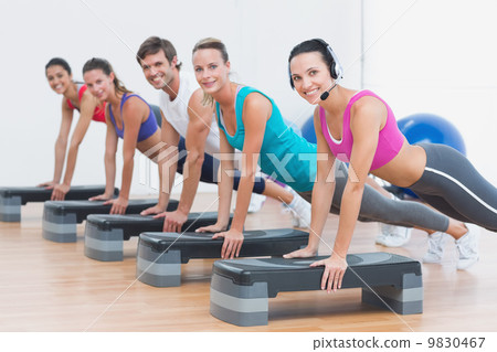 Fitness class doing step aerobics exercise 9830467