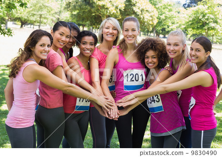 Female breast cancer marathon runners stacking hands 9830490