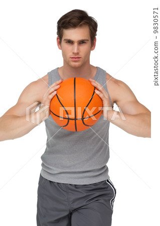 Fit man holding basketball about to throw to camera 9830571