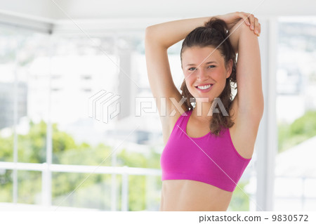Sporty young woman stretching hands at yoga class 9830572