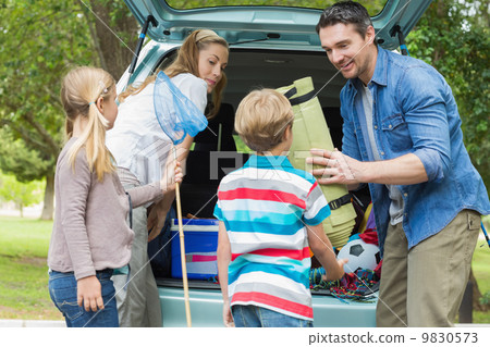Family unloading car trunk while on picnic 9830573