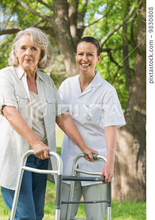 Female assisting mature woman with walker at park Female assisting mature woman with walker at park 9830808