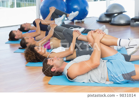 People stretching legs in fitness studio 9831014