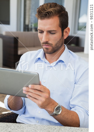 Serious young businessman working on tablet 9831121