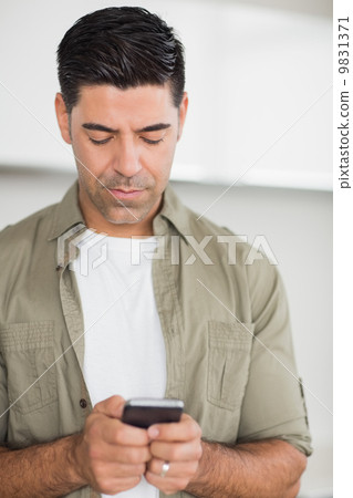 Serious man text messaging 9831371