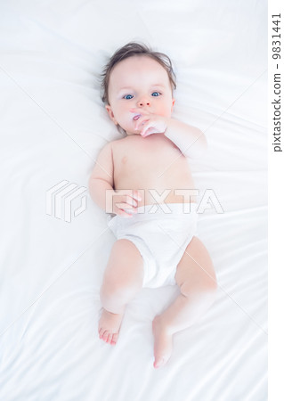 Innocent baby with finger in mouth 9831441