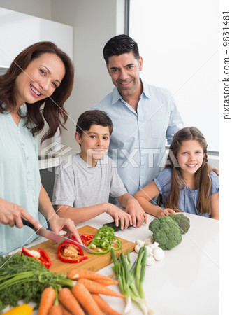 Family chopping vegetables in the kitchen 9831481