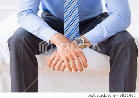 Businessman sitting on bed Businessman sitting on bed 9831483
