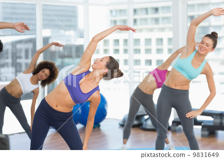 Sporty women stretching hands at yoga class 9831649