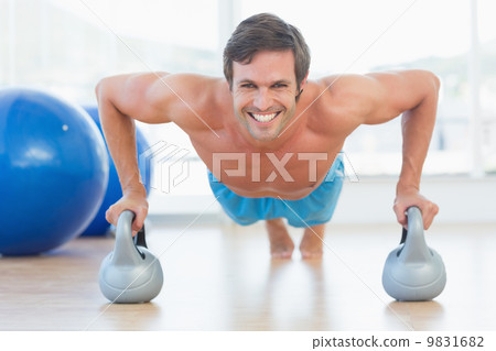 Portrait of a smiling young man doing push ups Portrait of a smiling young man doing push ups 9831682