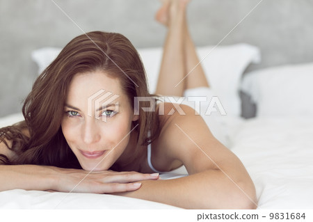 Closeup of a pretty smiling woman lying in bed Closeup of a pretty smiling woman lying in bed 9831684