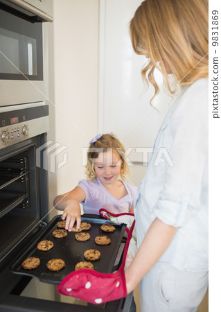 Mother and daughter baking cookies 9831869