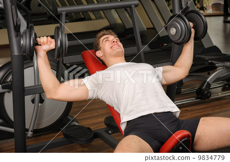 Young man doing Dumbbell Incline Bench Press workout in gym Young man doing Dumbbell Incline Bench Press workout in gym 9834779
