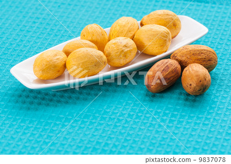 Nuts on a white saucer and near it 9837078