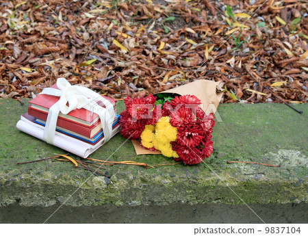 bouquet of chrysanthemums and a stack of books 9837104