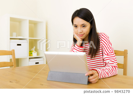 Asian woman looking at computer tablet 9843270
