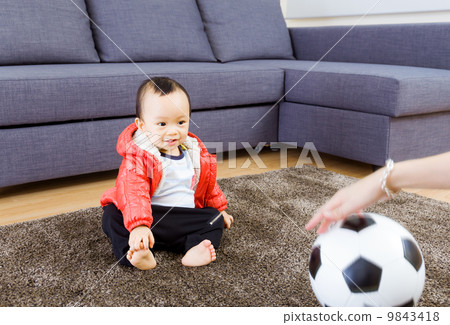 Asian baby looking at football 9843418