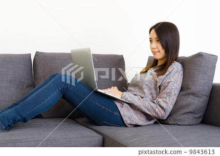 Asian woman using computer at home 9843613