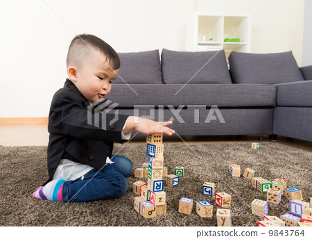 Little boy playing toy block at home 9843764