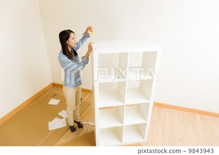 Asian woman assemble a white bookshelf 9843943
