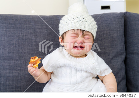 Little girl crying with bread holding on hand 9844027