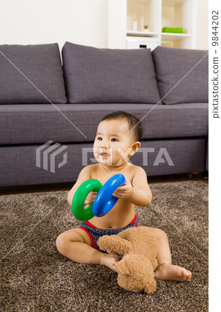 Baby seating on carpet and play doll 9844202