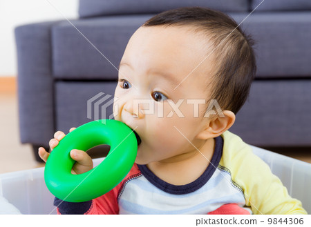 Asian baby boy biting toy 9844306