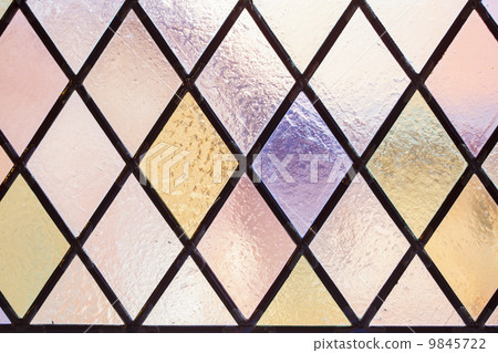 Stained glass with multi colored diamond pattern as background 9845722