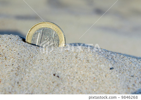 Euro coin in the sand 9846268