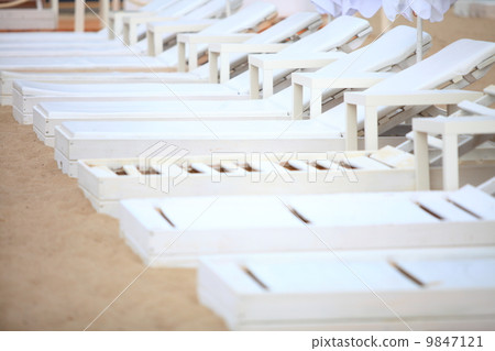 white pool chairs on sand beach 9847121