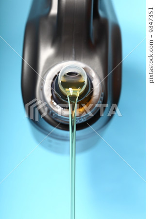 Can with car engine oil pouring blue background Can with car engine oil pouring blue background 9847351