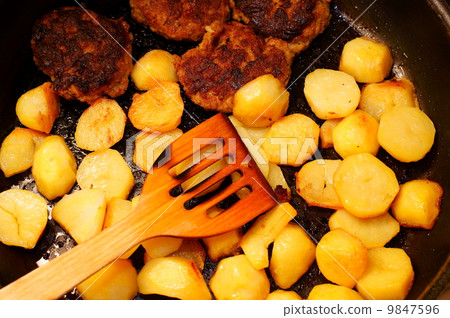 Seasoned potato slices in skillet pan in kitchen 9847596