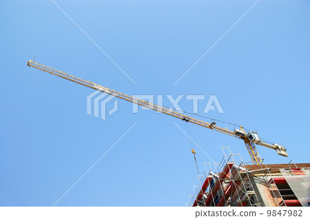 Building tower crane in action against a blue sky Building tower crane in action against a blue sky 9847982