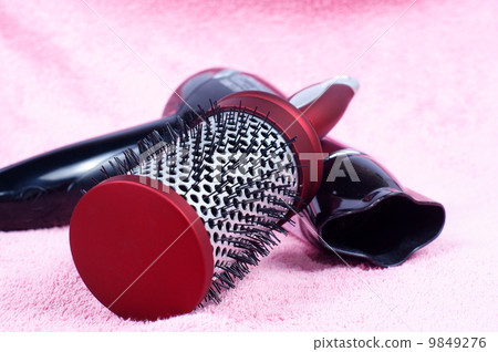 red round comb and hairdryer on rose background red round comb and hairdryer on rose background 9849276
