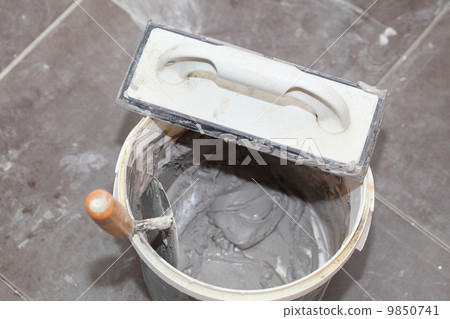 Dirty trowel and bucket on building site. Renovation at home 9850741