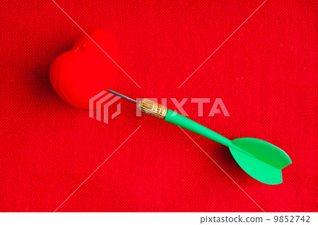 Blank copyspace and heart with dart on red fabric textile 9852742