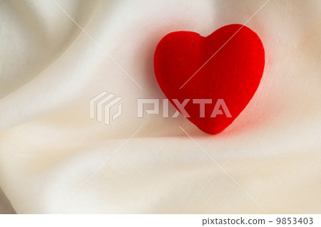 Red wooden decorative heart on white silk background. Red wooden decorative heart on white silk background. 9853403