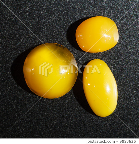 Closeup of three ambers golden minerals on black background 9853626