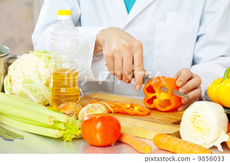 cook cuts pepper on cutting board cook cuts pepper on cutting board 9856033