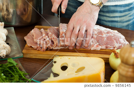 Hands cutting raw meat Hands cutting raw meat 9856145