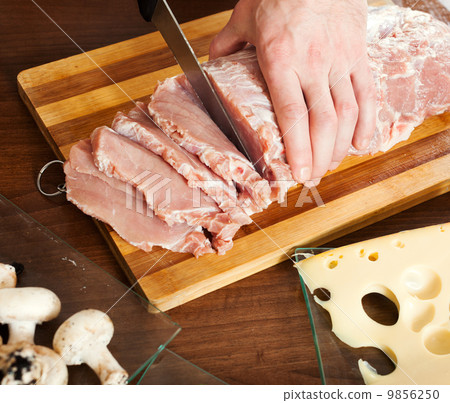 Hands cutting raw meat Hands cutting raw meat 9856250
