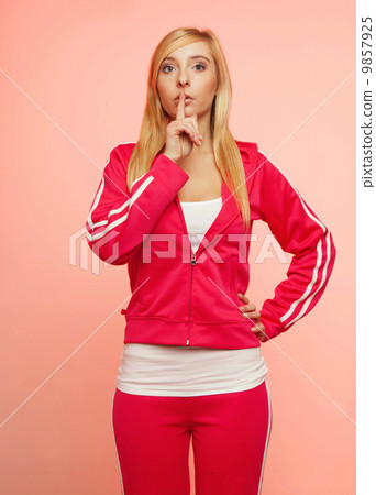 Secret woman. Fitness girl showing hand silence sign 9857925