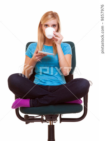 Beautiful girl relaxing in chair holds a cup of tea or coffee. 9857976