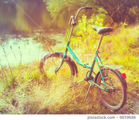Little green bicycle standing on green summer meadow Little green bicycle standing on green summer meadow 9859686