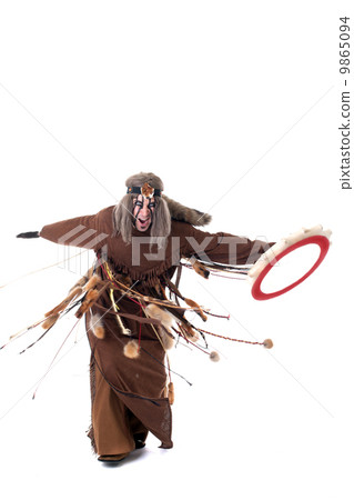 Shot of angry shaman dancing with tambourine Shot of angry shaman dancing with tambourine 9865094