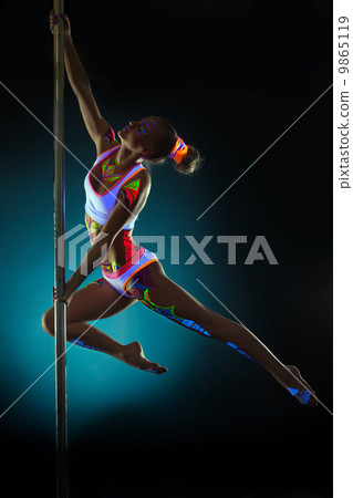 Graceful girl with neon makeup dancing on pilon Graceful girl with neon makeup dancing on pilon 9865119