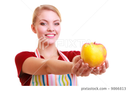 Happy housewife or chef in kitchen apron showing apple isolated Happy housewife or chef in kitchen apron showing apple isolated 9866813