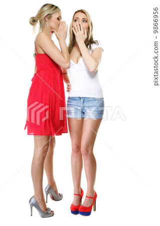 Gossiping friends, two women sharing a secret 9866956