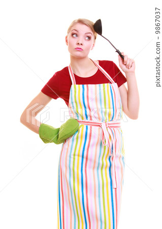 Funny housewife or cook chef in colorful kitchen apron with ladle Funny housewife or cook chef in colorful kitchen apron with ladle 9867037