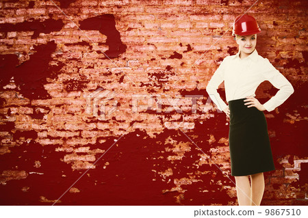 Female engineer woman architect in red safety helmet and red wall Female engineer woman architect in red safety helmet and red wall 9867510